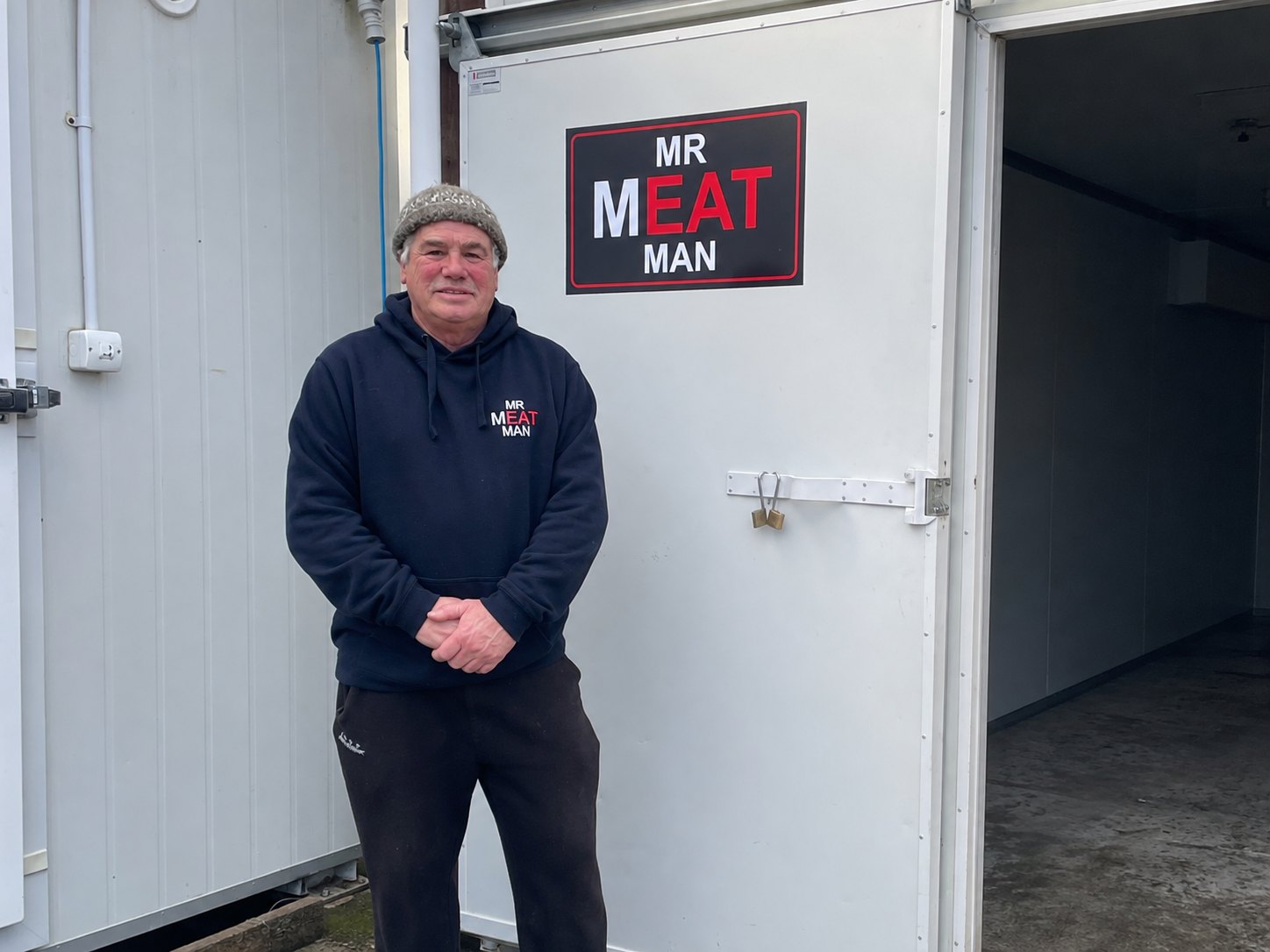 Mr Meat Man standing at the door of his Mr Meat Man chiller in Oropi, Bay of Plenty